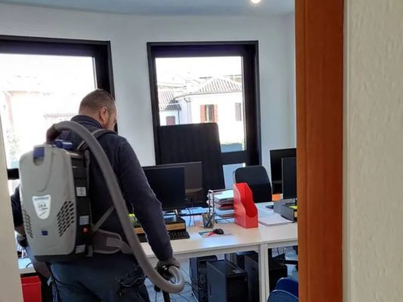 Pulizia di un ufficio con aspirapolvere a zaino